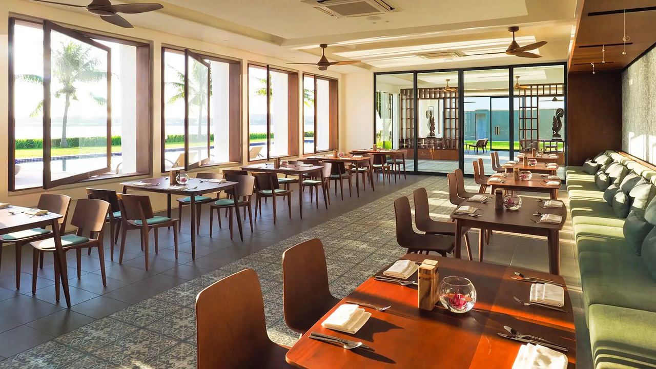 Theato, the restaurant of The Balé Phnom Penh, with tables by tall windows