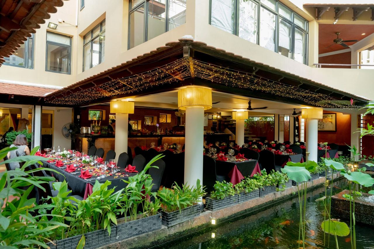 The courtyard at Malis, with its fish pond, lotus planters and dining terraces under lanterns