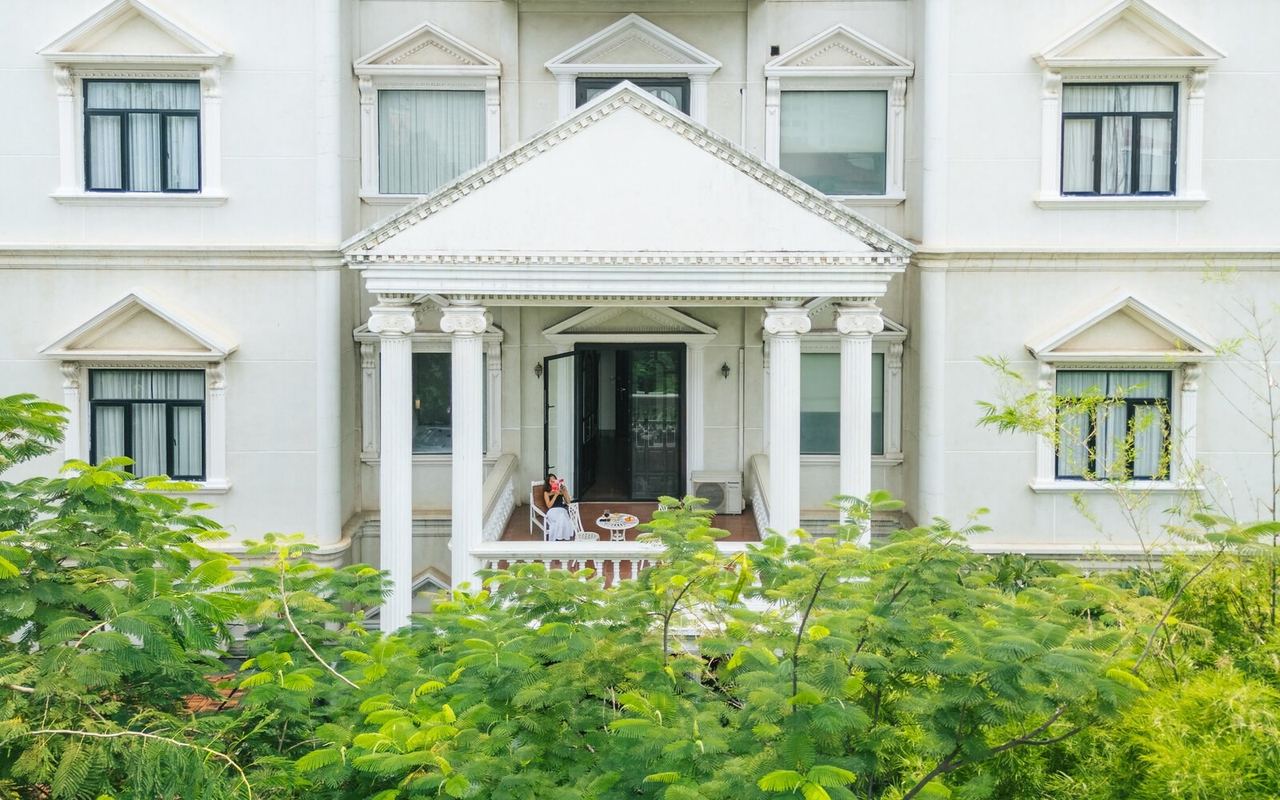 The white colonnaded façade of White Mansion above its garden